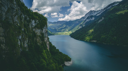 Fototapeta na wymiar aerial view of deep blue mountain lake in swiss alps, klontalersee switzerland