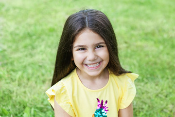 Portrait of a happy smiling child girl outdoors. Cute little girl playing in the park. 
