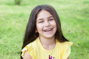 Portrait of a happy smiling child girl outdoors. Cute little girl playing in the park. 
