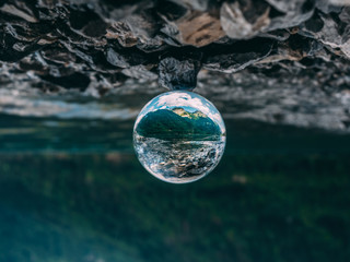 mountain scenery reflection in a glass ball, lensball. klontalersee in the alps