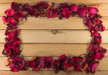 Red potpourri border on wood background with copy space