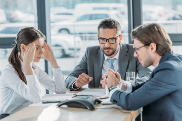Fototapeta premium serious business people having conversation and using speakerphone at modern office