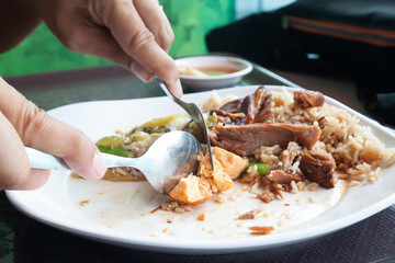 Man eating stewed pork leg with rice and egg, Close up unhealthy food