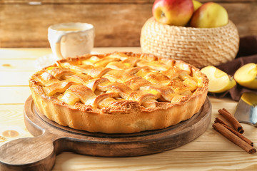 Board with delicious apple pie on wooden table