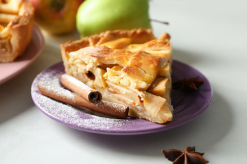 Plate with piece of delicious apple pie on light background, closeup