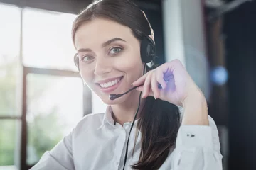 Foto op Plexiglas beautiful female call center worker with headphones looking at camera © LIGHTFIELD STUDIOS