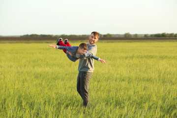 Happy father and son playing in the field