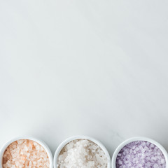 top view of colorful sea salt in bowls on white background