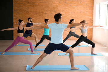 Obraz premium Group of people practicing yoga in gym