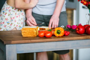 Fresh fruit and vegetables for healthy meal. Young couple making breakfast