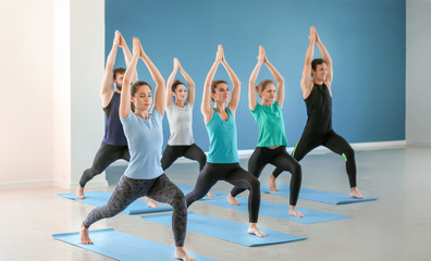 Fototapeta na wymiar Group of people practicing yoga in gym