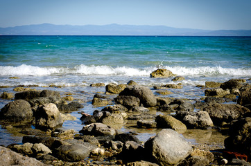 Fototapeta na wymiar каменный дикий морской пляж на фоне горных вершин