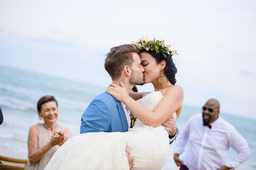 Cheerful newlyweds at beach wedding ceremnoy