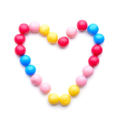 Heart made of different candies on white background