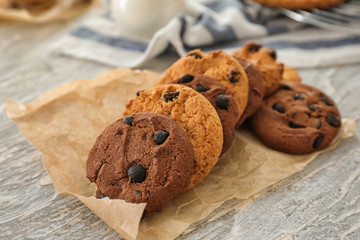 Delicious cookies with chocolate chips on light textured background