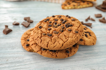 Delicious cookies with chocolate chips on white wooden background