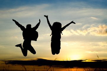 Silhouette of woman jumping at road during sunset.