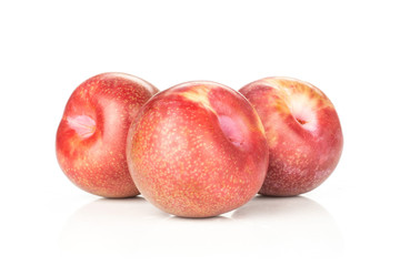 Group of three whole fresh pluot interspecific plums variety stack isolated on white