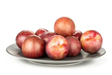 Lot of whole fresh pluot interspecific plums variety on a ceramic grey plate isolated on white