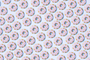 Sweets and desserts concept, donuts and cupcake cookies creative layout, simple pattern on trendy bright blue background, above