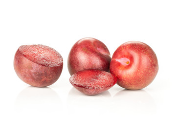 Group of two whole two halves of fresh pluot interspecific plums variety isolated on white