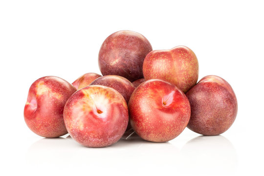 Lot of whole fresh pluot interspecific plums variety heap isolated on white