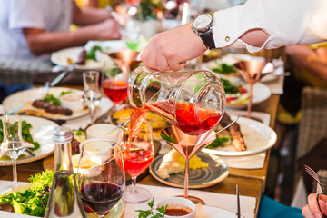 Professional waiter in uniform serving drinks to guests of event. Catering or celebration concept. Service at business, corporate meeting, party, weddings. Selective focus, space for text