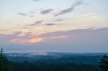 Cloudy sunrise over a foggy valley