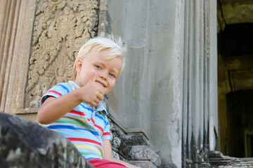Cute little boy 4 years old blond hair sitting outdoor