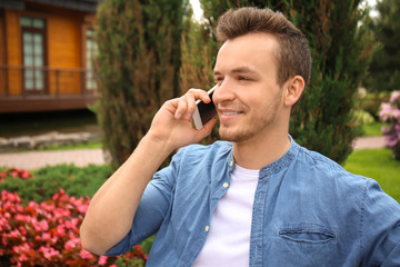 Young man talking on mobile phone outdoors