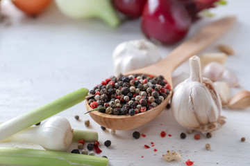 Spoon with spices and fresh garlic on light background