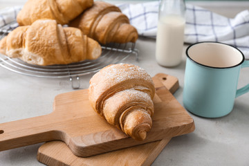 Wooden boards with tasty croissant on table