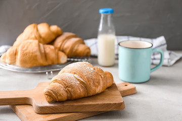 Wooden boards with tasty croissant on table