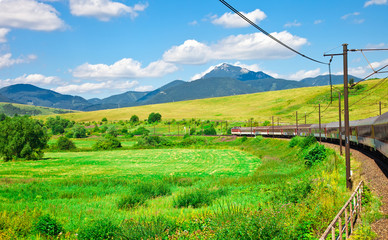 Rural landscape with moving train and the blue sky