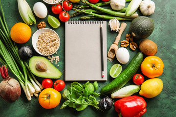 Various healthy products with notebook on color background