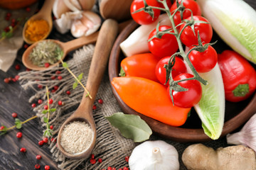 Bowl with vegetables and spices on wooden table