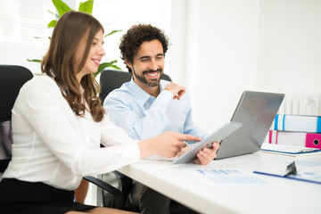 Fototapeta premium Smiling business people using a laptop computer
