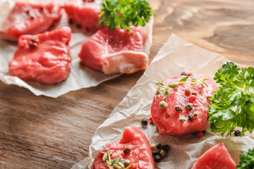 Fresh raw meat with spices and herbs on wooden table