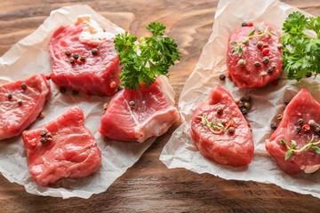 Fresh raw meat with spices and herbs on wooden table