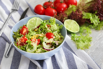 Bowl with quinoa salad on table
