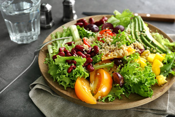 Plate with quinoa salad on grey background