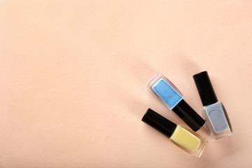 Fototapeta na wymiar Bottles of nail polishes on color background