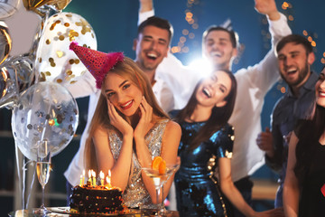 Obraz na płótnie Canvas Young woman near her birthday cake at party in club
