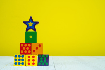 Square block puzzle toy on table with yellow background