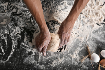 Man kneading dough on table