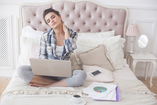 Young attractive woman working at home at the laptop