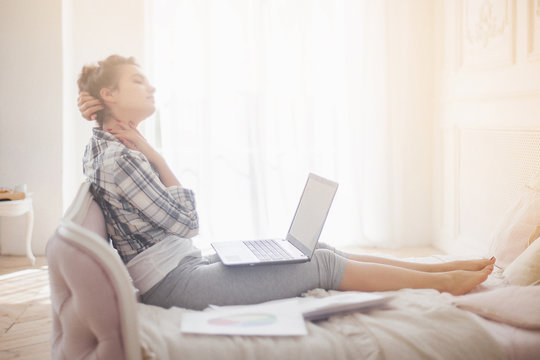 Young attractive woman working at home at the laptop