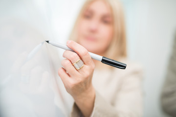 Business woman writing on a whiteboard in her office
