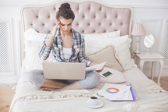 Young attractive woman working at home at the laptop