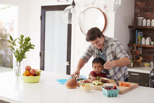 Father And Son Making School Lunch In Kitchen At Home